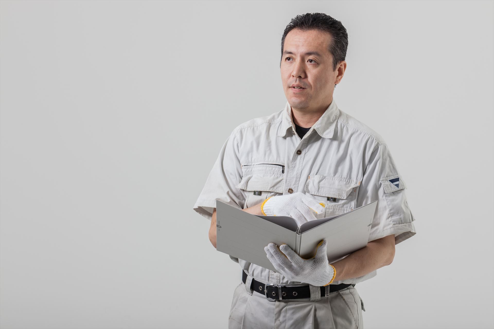 話をする作業服の男性_R